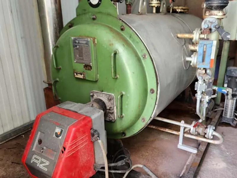 Caldera de vapor verde con su quemador tras una reparación